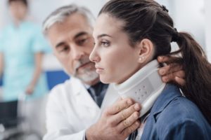 Personal Injury Lawyer Anaheim, CA with a doctor examining a woman's neck that's wearing a brace