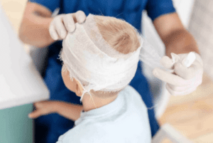 Doctor wrapping patient's head after an injury and meeting with a Brain Injury Lawyer Anaheim, CA